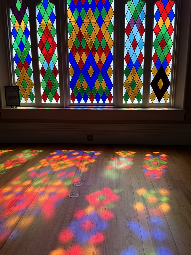 Buntglasfenster und farbiges Licht auf dem Holzboden