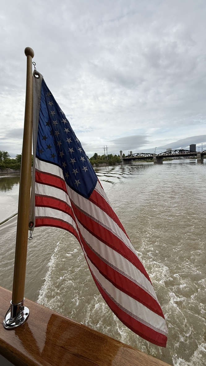 US-Flagge am Heck eines Holzboots auf dem Wasser