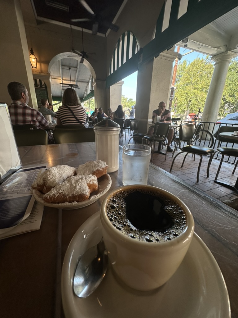 Beignets mit Puderzucker und Kaffee unter den Arkaden