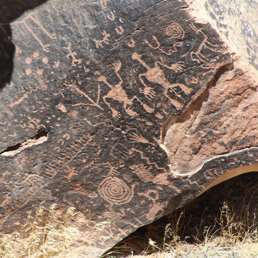 Petroglyphen auf einem dunklen Felsblock