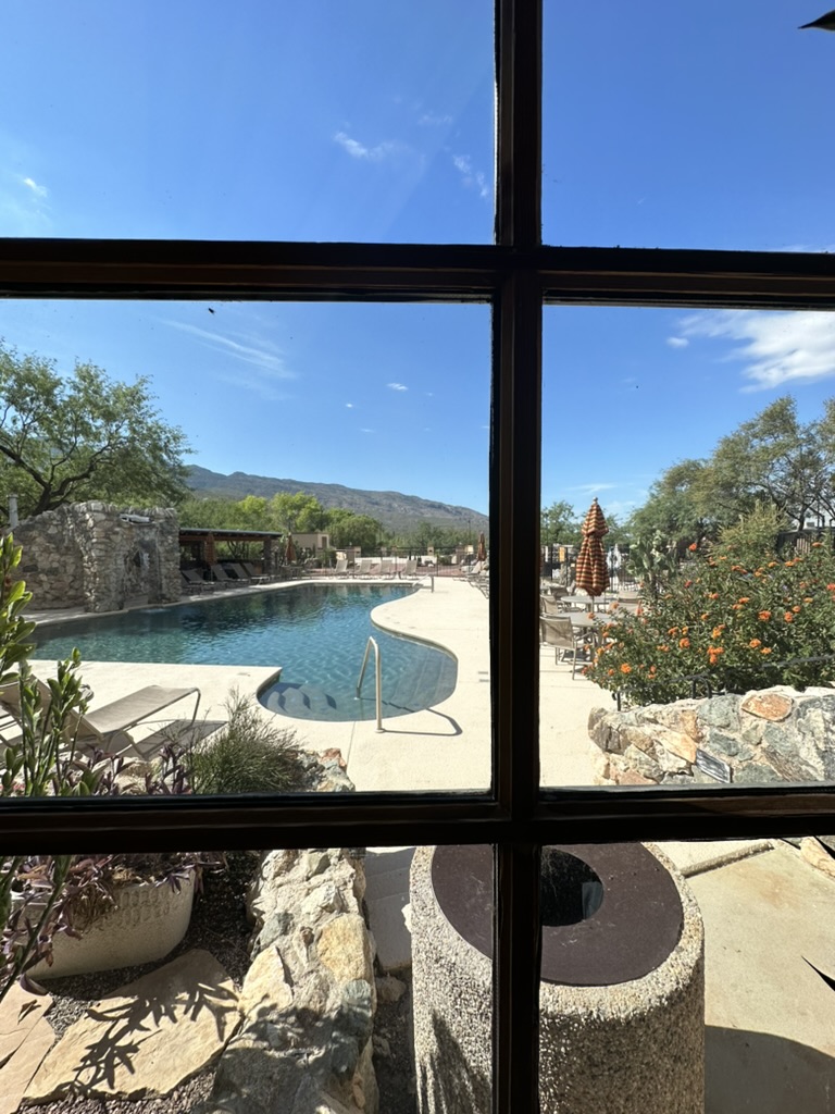 Blick durchs Fenster auf den Pool einer Ranch