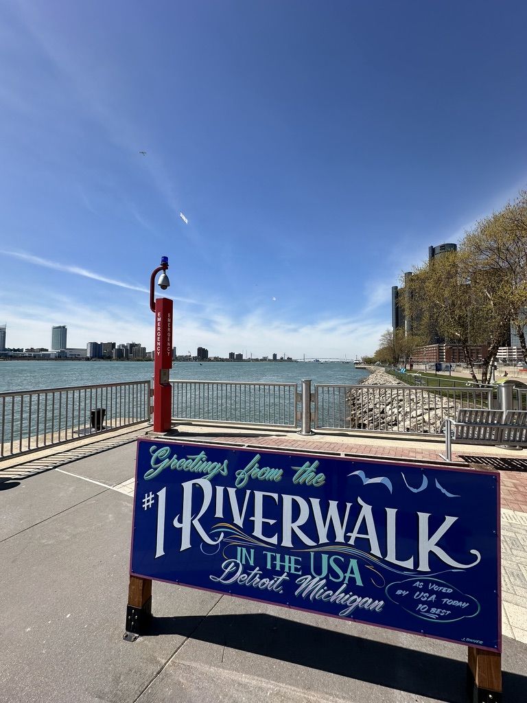 Schild „Greetings from the #1 Riverwalk in the USA“ am Detroit River