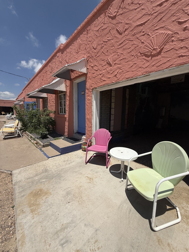 Zimmerreihe mit offener Garage und Metallstühlen