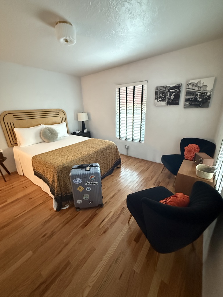 Motelzimmer mit Holzboden, Bett im Stil der 1940er-Jahre und Sesseln