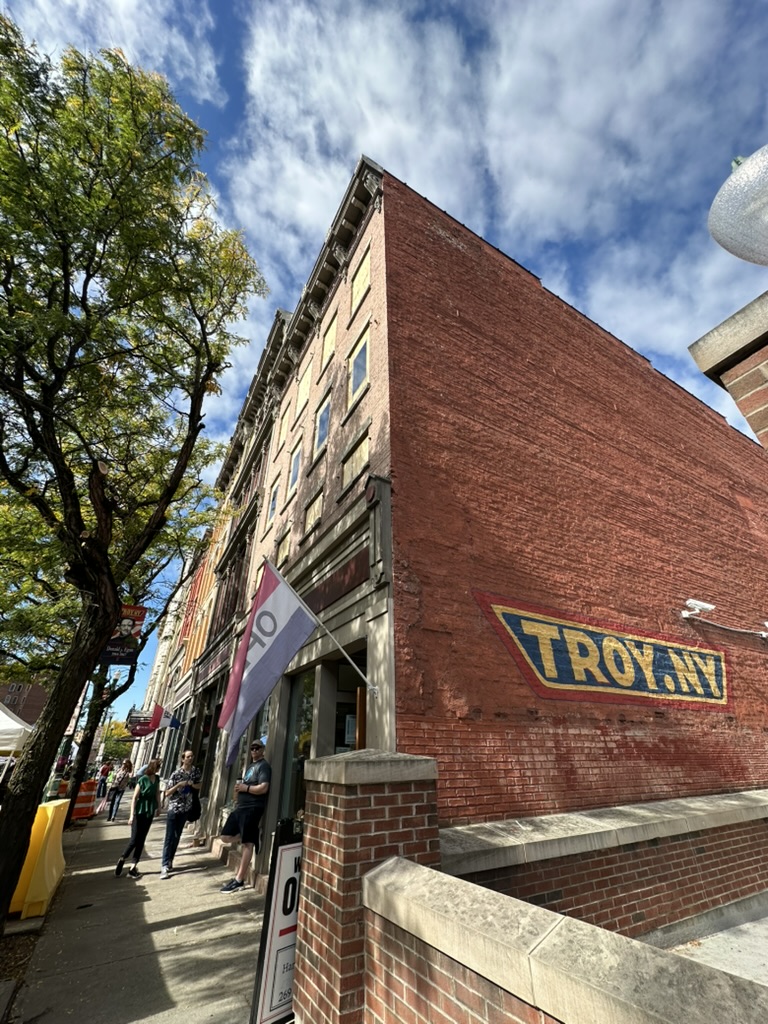 Backsteinhaus mit dem Schriftzug TROY.NY in der Innenstadt