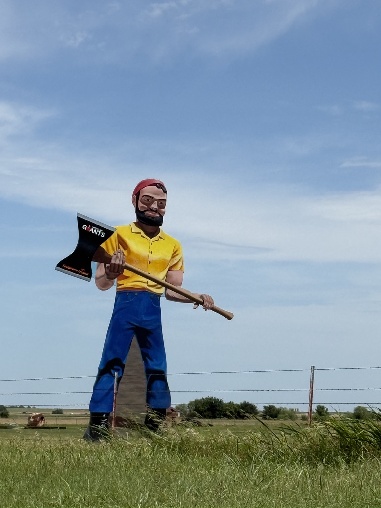 Große Figur eines Holzfällers mit Axt an einer Weide entlang der Route 66