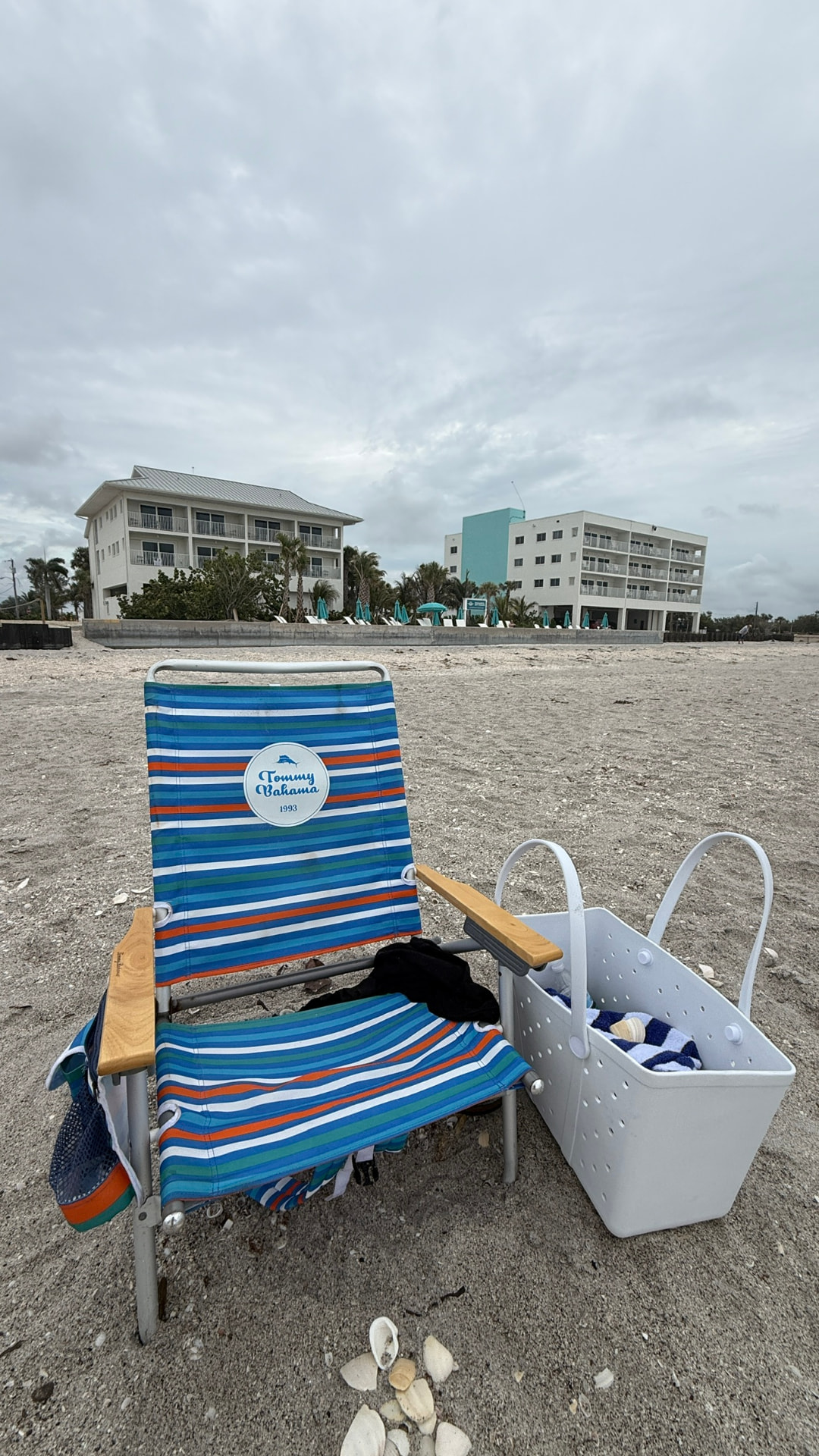 Gestreifter Strandstuhl und Strandtasche vor dem Resort