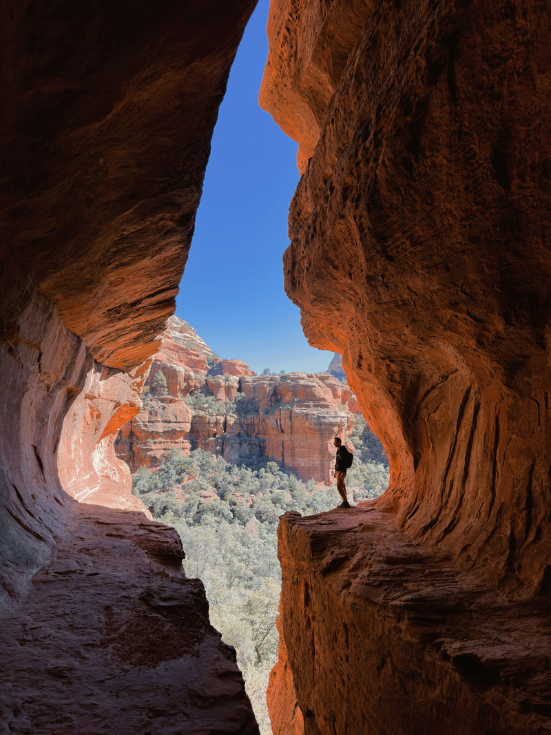 Wanderer in einer roten Felsspalte bei Sedona mit Blick auf die Canyonlandschaft