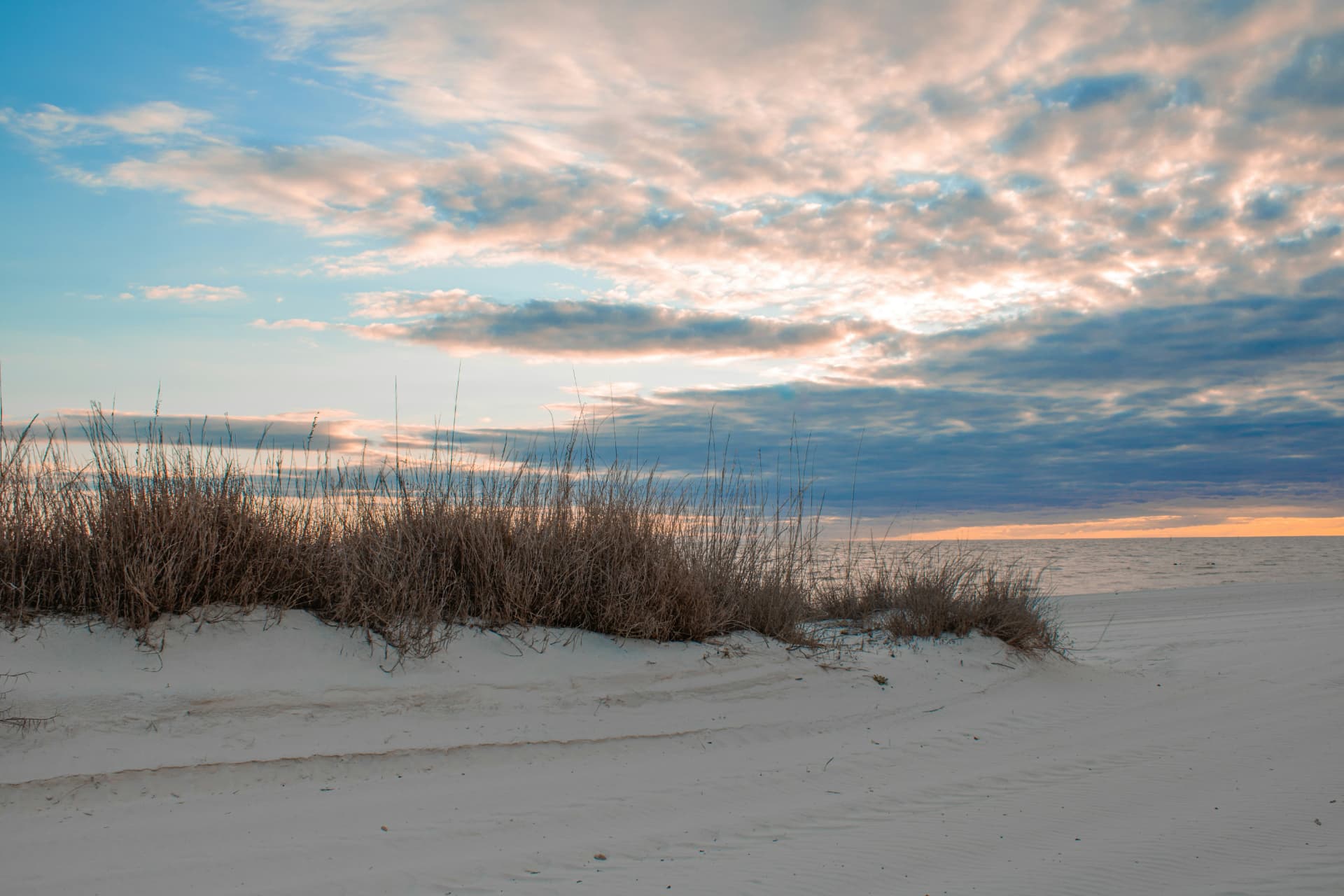 Weißer Strand mit Dünengras bei Sonnenuntergang in Biloxi, Mississippi