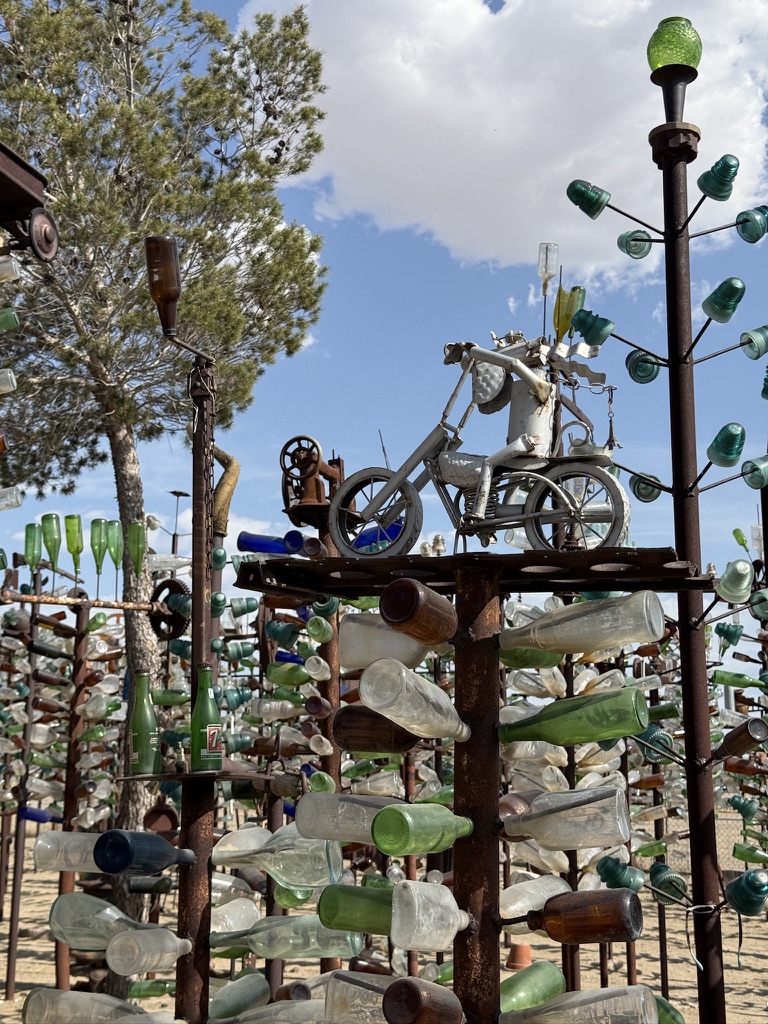 Metallbäume mit bunten Glasflaschen und eine Motorradfigur aus Metall auf der Bottle Tree Ranch