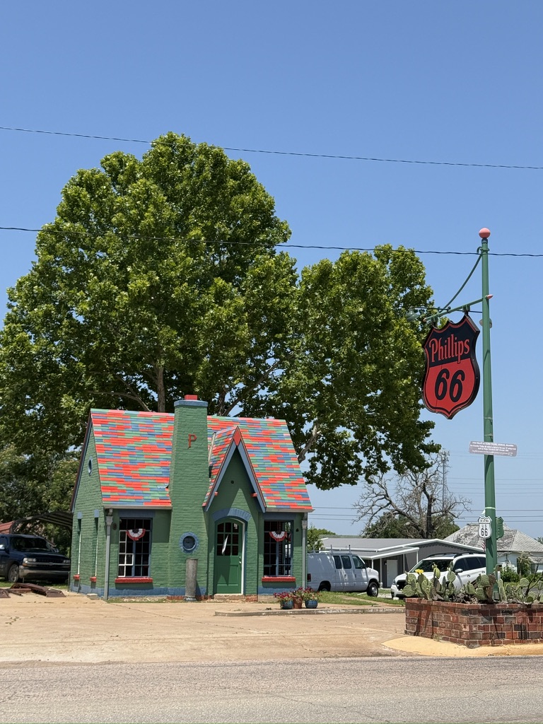 Restaurierte Phillips-66-Tankstelle im Cottage-Stil mit buntem Dach und Emailleschild