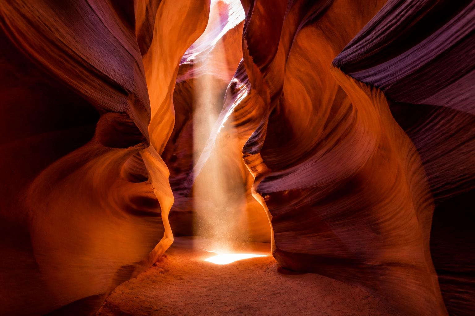 Lichtstrahl fällt durch die Sandsteinwände des Antelope Canyon auf den Boden